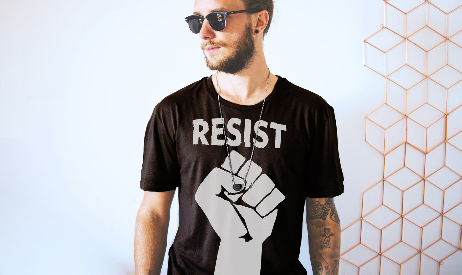 Male model wearing RESIST t-shirt in white on black Live Love Be Peace.